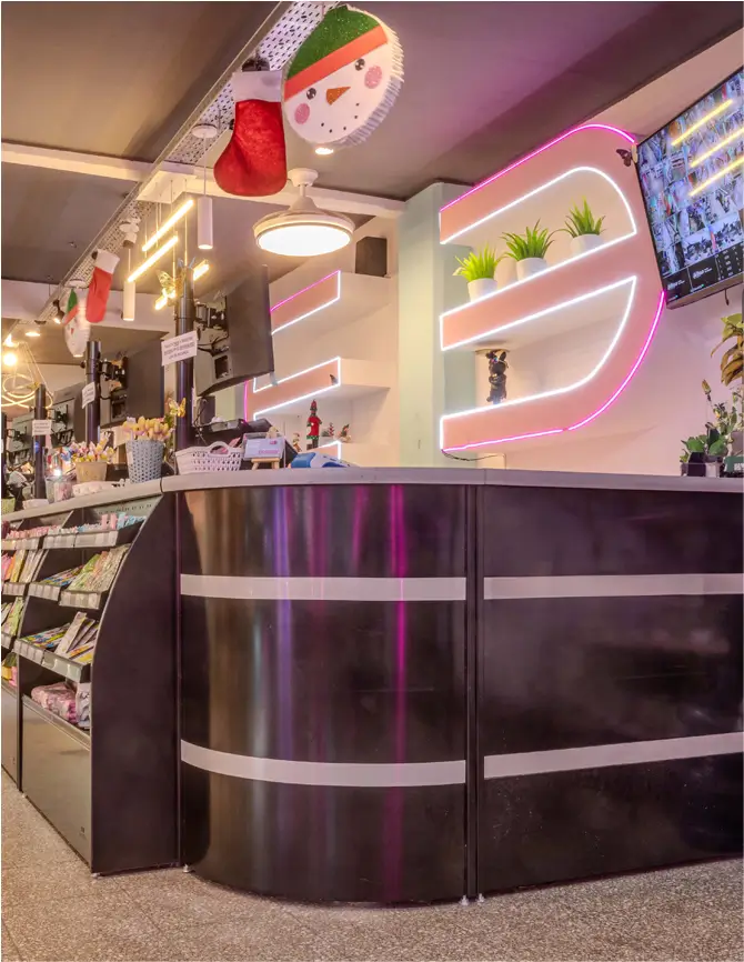 Sector de caja con exhibidores iluminados y adornos festivos en una tienda moderna