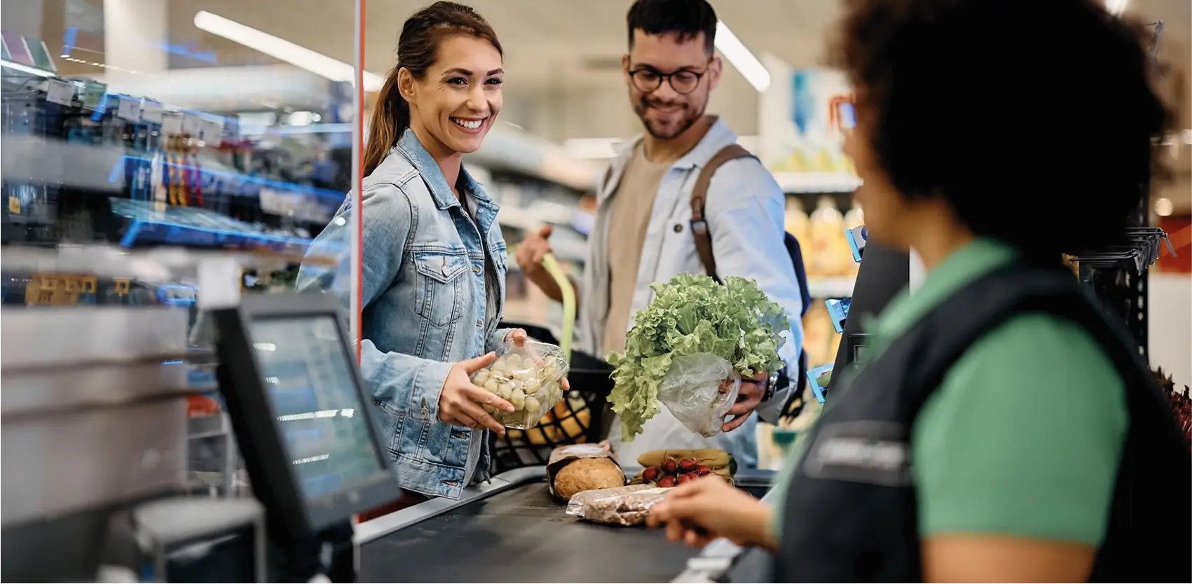 Checkout y góndolas comerciales para supermercados Clientes comprando en supermercado con góndolas comerciales y caja checkout moderna