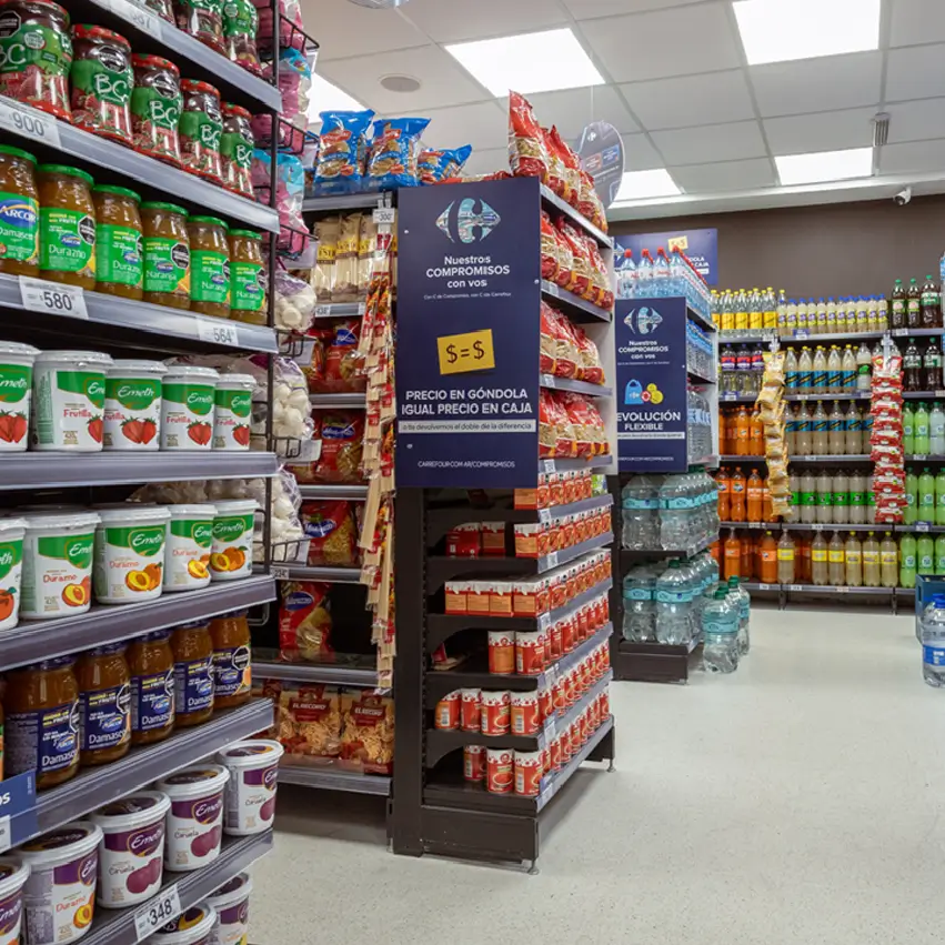 Puntera promocional en góndola central de supermercado con productos de consumo masivo organizados por categorías