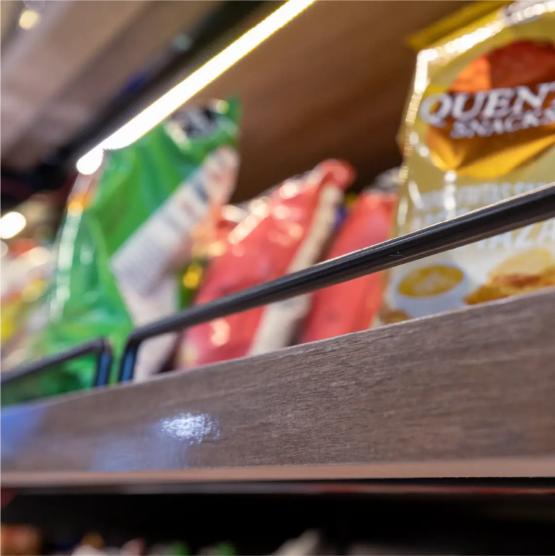 Góndolas comerciales de madera y metal en almacén moderno con iluminación LED en Local PLAZA Almacén Fiambrería