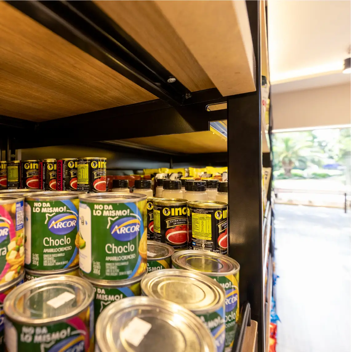 Góndolas comerciales de madera y metal en almacén moderno con iluminación LED en Local PLAZA Almacén Fiambrería