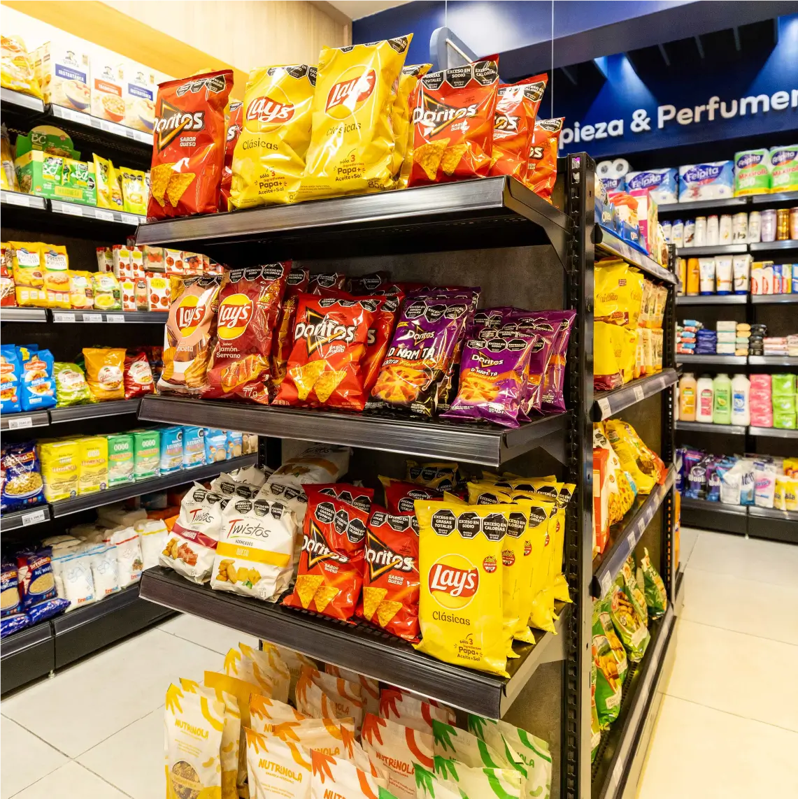 Exhibidor central con snacks en góndolas metálicas de supermercado